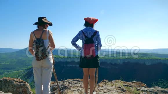 两个女旅行家的女朋友走在高原上欣赏美丽的景色视频的预览图