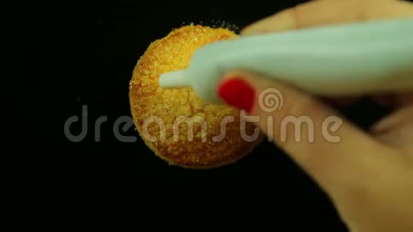 一只雌性手拿着一管烹饪黄色果酱在饼干上画着有趣的表情符号时间跨度视频的预览图