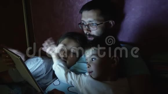 父亲带着小孩在睡觉前上网视频的预览图