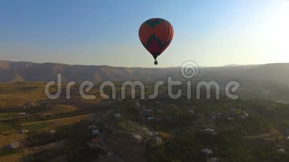 美丽的热气球在村庄上空的华丽飞行极限运动视频的预览图