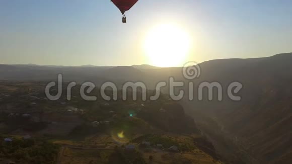 红色热气球准备软着陆在亚美尼亚山村视频的预览图