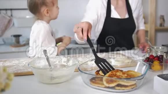 可爱的妈妈和她的小女儿一起做奶酪薄饼视频的预览图