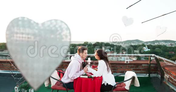 屋顶上的浪漫约会幸福美丽的情侣牵着手温柔地接吻4K录像视频的预览图