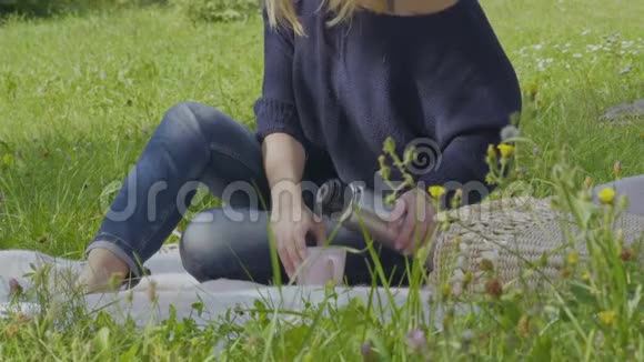 年轻女子喜欢公园里的大自然喝热水瓶里的茶视频的预览图