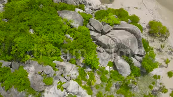 鸟瞰大海绿岛上的大岩石从无人驾驶飞机飞过岩石岛和沙滩的海景视频的预览图