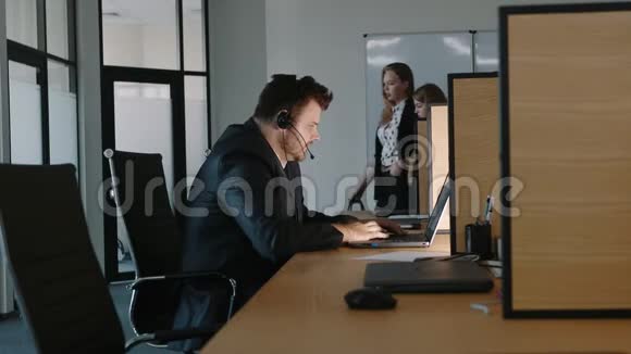 一名办公室雇员在工作日结束时在笔记本电脑上工作视频的预览图