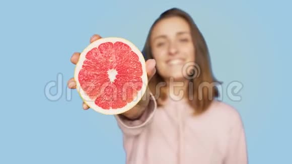 可爱的笑脸女人捧着粉色葡萄柚视频的预览图