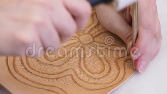 工匠用背景冲压工具在皮革上贴上浮雕图片视频的预览图