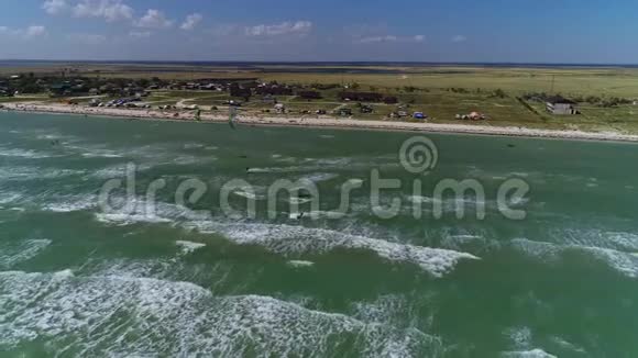 海浪在海上人们在海滩营地的背景下进行风筝冲浪视频的预览图