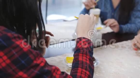 年轻漂亮的女朋友坐在窗边的咖啡馆里喝拿铁可爱的女孩笑说话喝咖啡视频的预览图