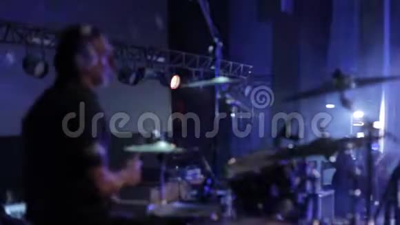 布鲁尔在舞台上表演的专业鼓手的侧视音乐会灯光背景上的聚光灯视频的预览图