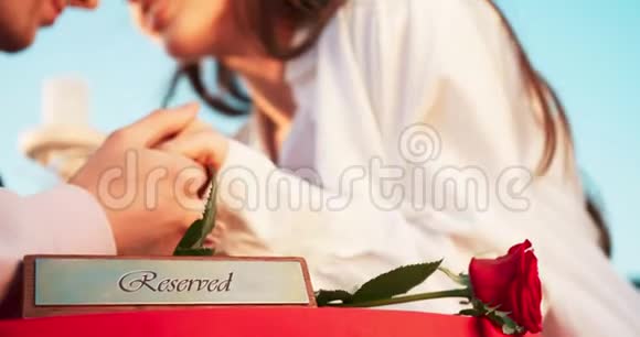 浪漫的构图在这对温柔相爱的夫妇模糊的背景下桌子上保留着匾额和红玫瑰视频的预览图