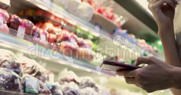 超市的女人用智能手机视频的预览图