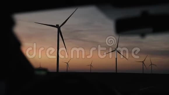 驾着美丽的落日天空驶过风车视频的预览图