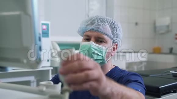 一家医院的医生穿着无菌衣服和口罩使用诊断设备超声检查视频的预览图