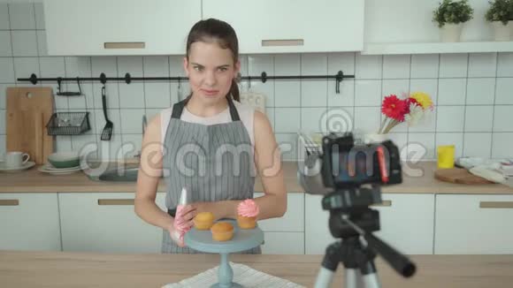 烹饪博客年轻女人用奶油装饰蛋糕视频的预览图