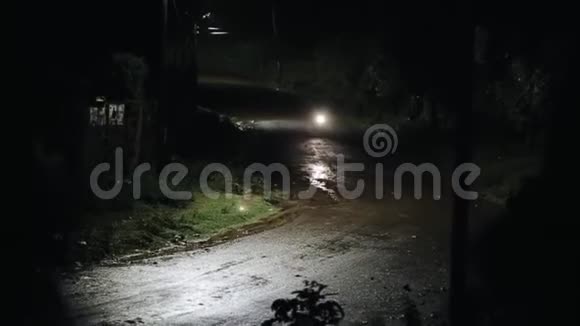 摩托车手在雨中深夜骑在一条潮湿的路上看雨和灯视频的预览图
