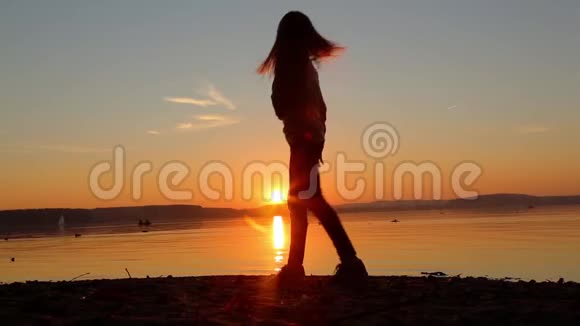 傍晚日落时分女孩在海滩上跳舞视频的预览图