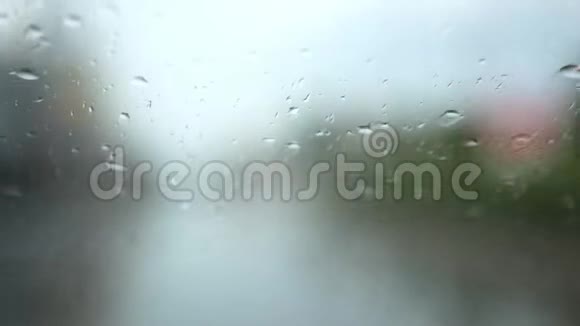 雨天驾驶汽车斜挡风玻璃上雨的选择性聚焦背景视频的预览图