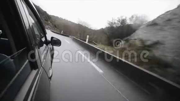 一辆黑色汽车沿着弯曲的山路行驶在山里旅行视频的预览图