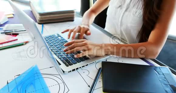 女性高管中段使用图形平板电脑同时使用笔记本电脑4k视频的预览图