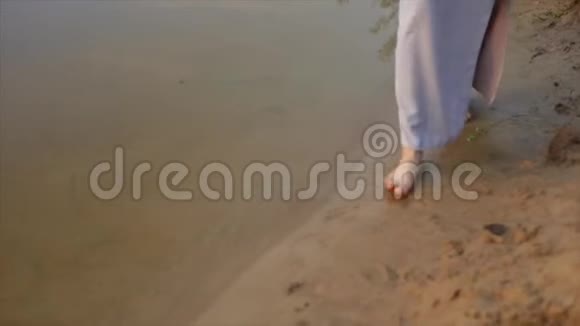 傍晚在海滩上赤脚奔跑的苗条女孩的后景慢动作视频的预览图