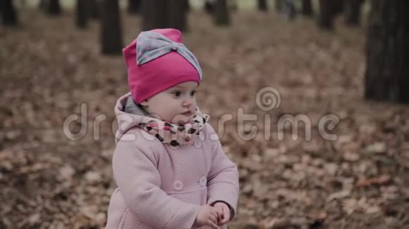 漂亮的小女孩独自在公园里散步视频的预览图