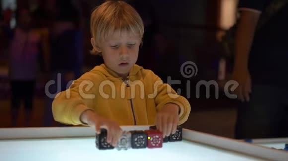 一个小男孩参观儿童科学博物馆的慢镜头他玩的是模块化机器人视频的预览图