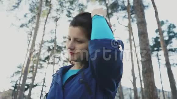 公园里一个年轻漂亮的女人笑着玩她的头发4K视频的预览图