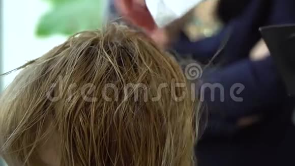 美容院理发店斯特里斯特把头发给他的客户特写镜头慢动作视频的预览图