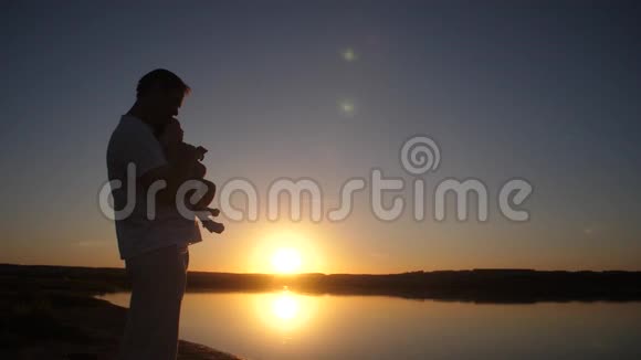 太阳落山时人类在远处展示婴儿手指慢动作视频的预览图