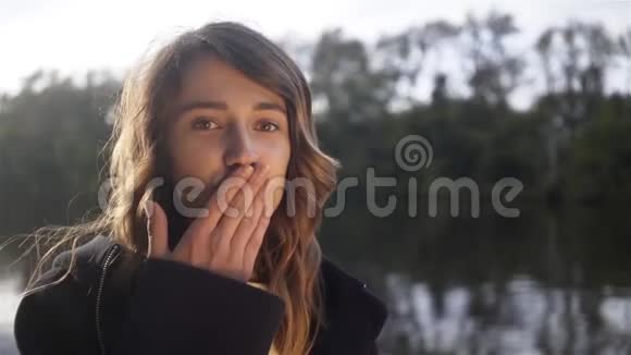 一个年轻的女人在一条河里一艘船上给镜头送一个空气吻视频的预览图
