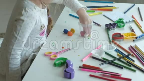 一个快乐的小女孩从一个容器里拿出五颜六色的塑料桌面上摆着数字和彩色铅笔视频的预览图