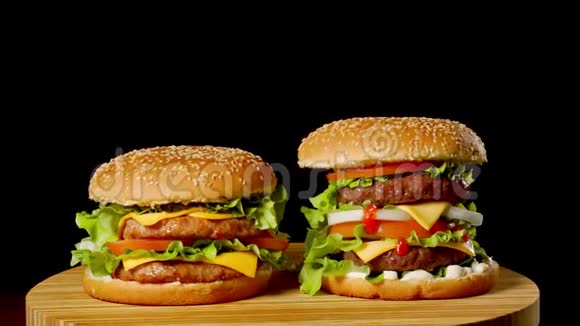 美国快餐的概念带有两个牛肉片的美国辣汉堡加酱和黑肉视频的预览图