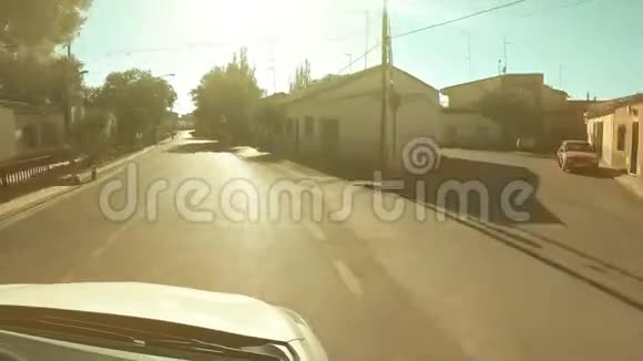 在阳光明媚的夏日POV驾驶镜头穿越西班牙小镇视频的预览图