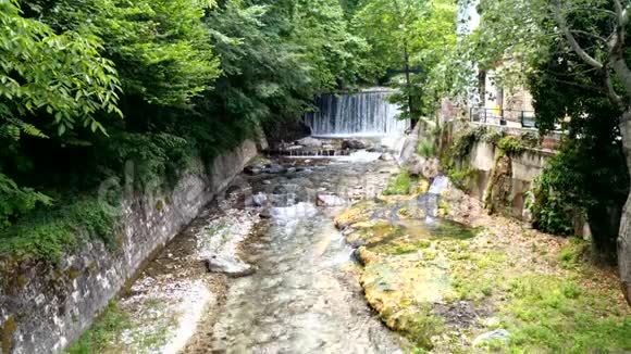 希腊波扎尔阿里亚温泉中树木之间的小河视频的预览图