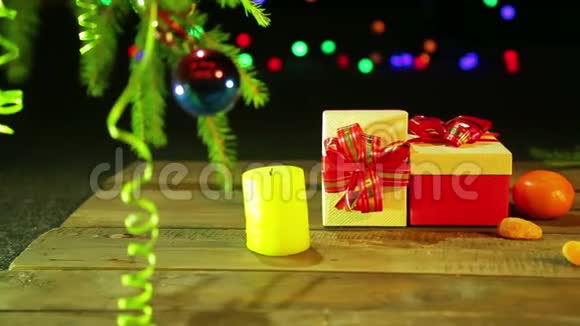 圣诞树旁边的桌子上放着圣诞礼物黑色背景上放着灯的橘子视频的预览图