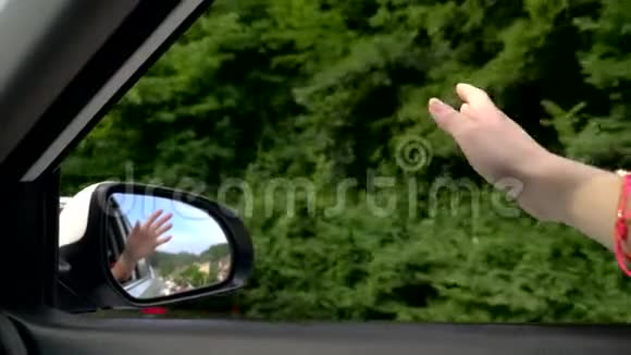 自由自动旅行和冒险的概念一个女司机在路上开车时感觉到风从她的手中吹来视频的预览图