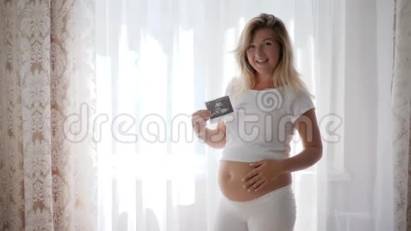 孕妇手中婴儿裸孕腹部超声照片视频的预览图