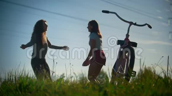 两个小女孩热身骑自行车前跳晴天视频的预览图