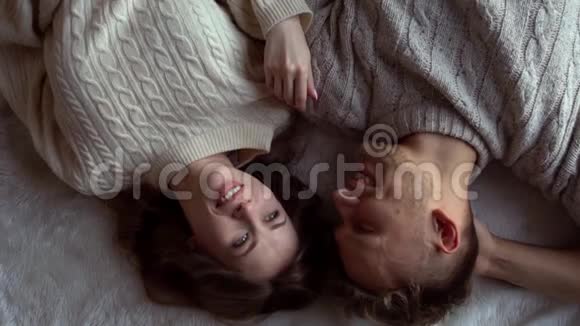 一对年轻夫妇在家一起冬概念躺着说话视频的预览图