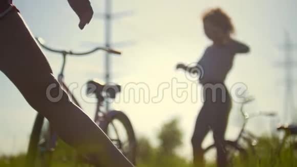 一个年轻的骑自行车的人弯着腿背景是女孩在喝水视频的预览图
