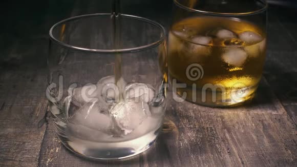 带冰倒威士忌的玻璃杯中的慢动作视频的预览图