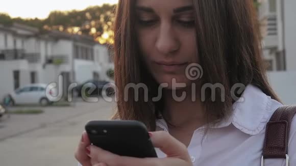 在住宅区别墅背景下使用智能手机的年轻女性视频的预览图