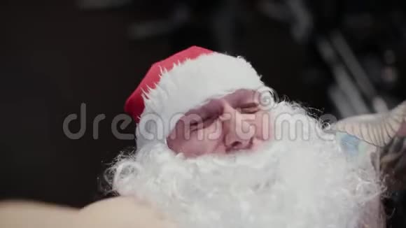 健身教练圣诞老人在健身房的模拟器上面部特写视频的预览图
