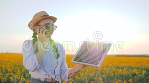 自然资源女人在背光谈话移动和保持太阳能电池跟踪太阳充电电池女孩说话视频的预览图