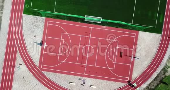 从鸟瞰空旷运动场的一部分打大型网球和篮球的红色运动场视频的预览图