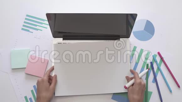 商业概念女人在笔记本电脑上的一张纸上写字视频的预览图
