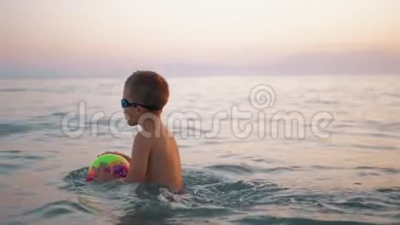 孩子把球带到水里然后在海里漂浮视频的预览图