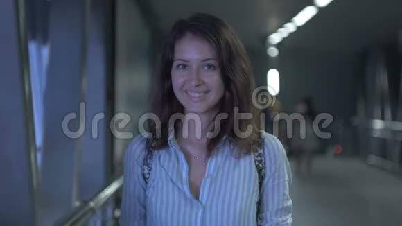 一位美丽的年轻女子在夜晚微笑的城市视频的预览图